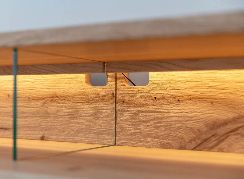 Beleuchtete Hängekommode aus massiver Eiche und Glas | TV-Board Tirano IV mit Schaukasten und grober Holzstruktur