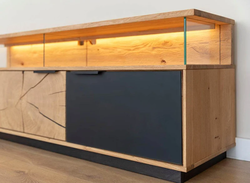 Beleuchtete Hängekommode aus massiver Eiche und Glas | TV-Board Tirano IV mit Schaukasten und grober Holzstruktur