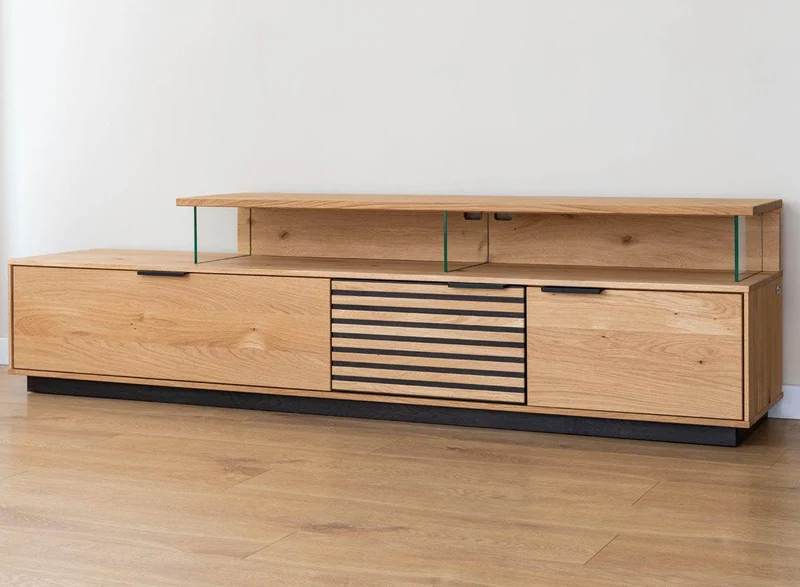 Beleuchtete Hängekommode aus massiver Eiche mit Lamellen | TV-Board Tirano II mit Schaukasten und grober Holzstruktur