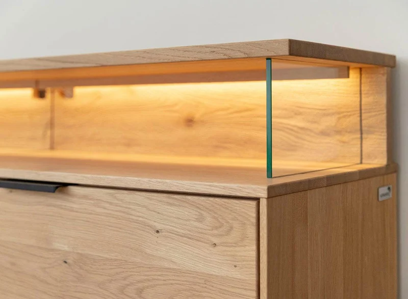 Beleuchtete Hängekommode aus massiver Eiche | TV-Board Tirano I mit Schaukasten und grober Holzstruktur