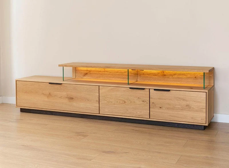 Beleuchtete Hängekommode aus massiver Eiche | TV-Board Tirano I mit Schaukasten und grober Holzstruktur