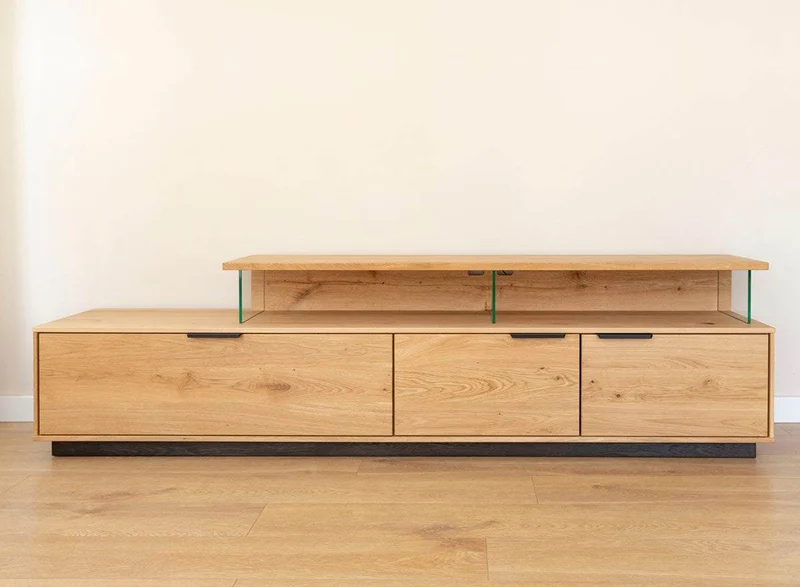 Beleuchtete Hängekommode aus massiver Eiche | TV-Board Tirano I mit Schaukasten und grober Holzstruktur