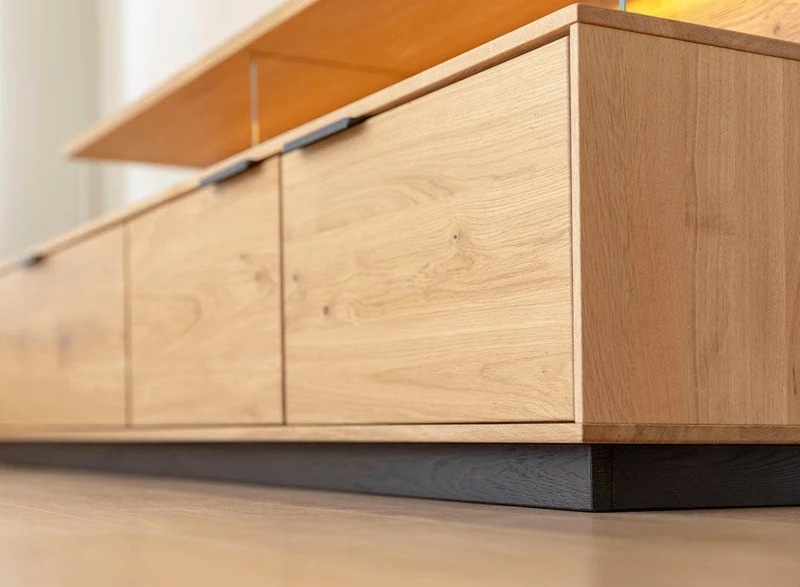 Beleuchtete Hängekommode aus massiver Eiche | TV-Board Tirano I mit Schaukasten und grober Holzstruktur