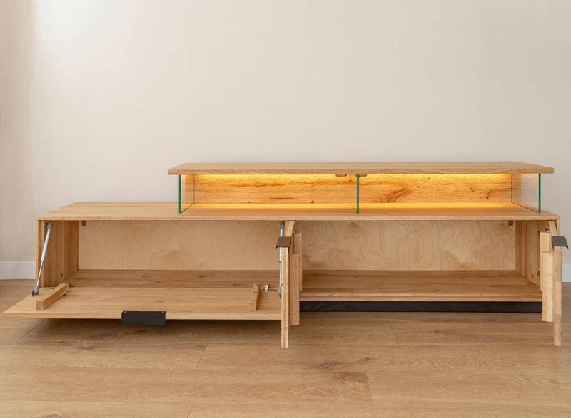 Beleuchtete Hängekommode aus massiver Eiche | TV-Board Tirano I mit Schaukasten und grober Holzstruktur