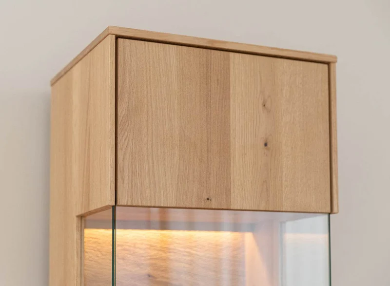 Beleuchtete Hängevitrine aus massiver Eiche | Vitrine Tirano I mit Rückwand in grober Holzstruktur